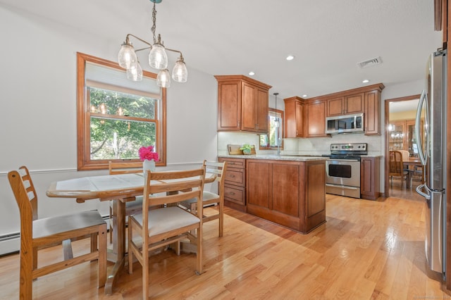 31 S Meadow Ln, Enfield, CT 06082 - kitchen featuring stainless steel appliances, brown cabinets, decorative light fixtures, light wood-style floors, and tasteful backsplash