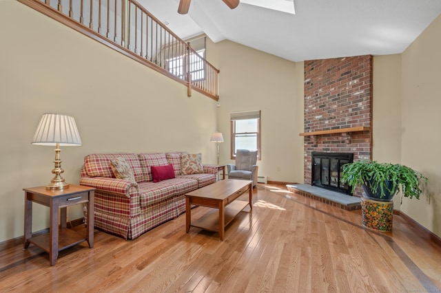 31 S Meadow Ln, Enfield, CT 06082 - living area featuring ceiling fan, hardwood / wood-style floors, a brick fireplace, high vaulted ceiling, and baseboards
