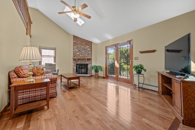 31 S Meadow Ln, Enfield, CT 06082 - living room featuring a baseboard radiator, light wood-style floors, a ceiling fan, a fireplace, and high vaulted ceiling