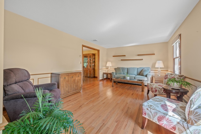 31 S Meadow Ln, Enfield, CT 06082 - living room featuring light wood-style floors, a wainscoted wall, and a decorative wall