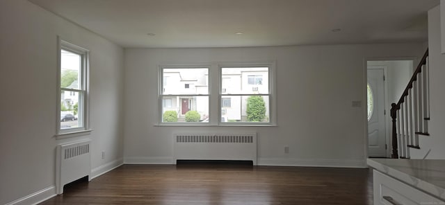 265 Harlem Ave, Bridgeport, CT 06606 - unfurnished living room featuring radiator, stairs, dark wood finished floors, and baseboards