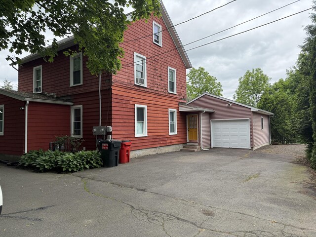 39 Swain Ave, Meriden, CT 06450 - view of side of property with asphalt driveway, entry steps, and an attached garage