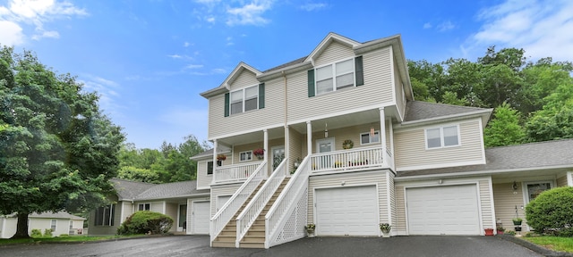 2 Turtle Spring Ln Unit 2, Newtown, CT 06470 - view of front of house with driveway, covered porch, stairs, a garage, and a shingled roof