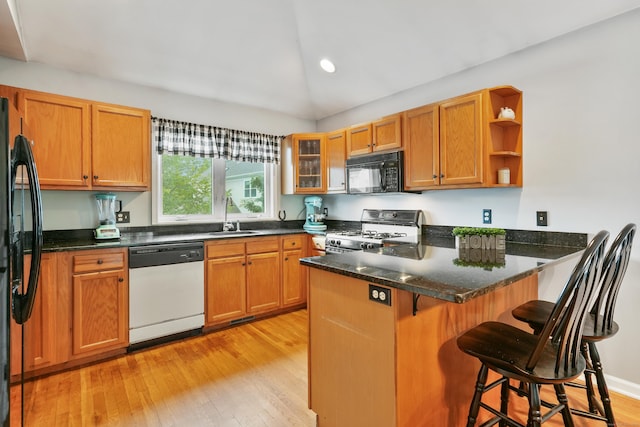 2 Turtle Spring Ln Unit 2, Newtown, CT 06470 - kitchen with black appliances, a peninsula, open shelves, light wood finished floors, and vaulted ceiling