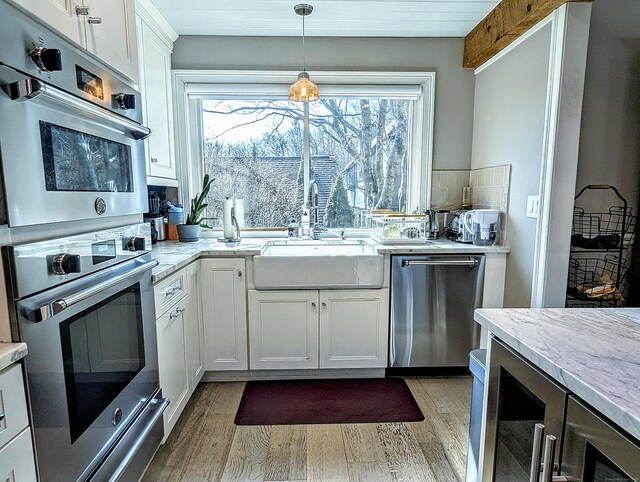 1036 Heritage Vlg Unit A, Southbury, CT 06488 - kitchen featuring appliances with stainless steel finishes, a sink, light wood finished floors, and white cabinetry