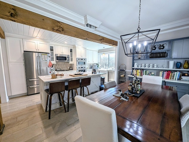 1036 Heritage Vlg Unit A, Southbury, CT 06488 - dining space with a chandelier, light wood-style floors, and crown molding