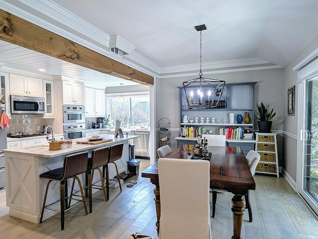 1036 Heritage Vlg Unit A, Southbury, CT 06488 - dining space with light wood-style floors, a chandelier, and crown molding