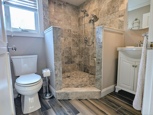 1036 Heritage Vlg Unit A, Southbury, CT 06488 - bathroom featuring toilet, a tile shower, vanity, wood finished floors, and baseboards