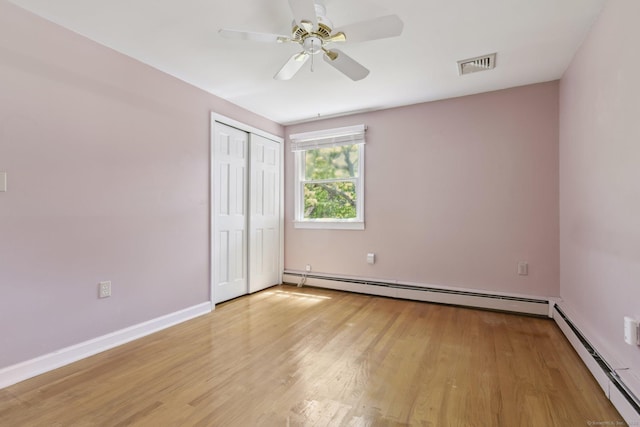 205 Ocean View Ave, Groton, CT 06355 - unfurnished bedroom featuring a baseboard heating unit, light wood-style flooring, and a closet