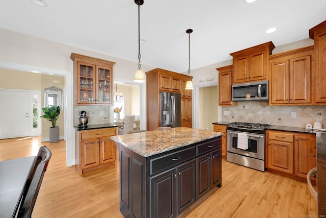 15 Lafountain Rd, Suffield, CT 06078 - kitchen featuring stainless steel appliances, light wood-style flooring, decorative backsplash, pendant lighting, and a kitchen island