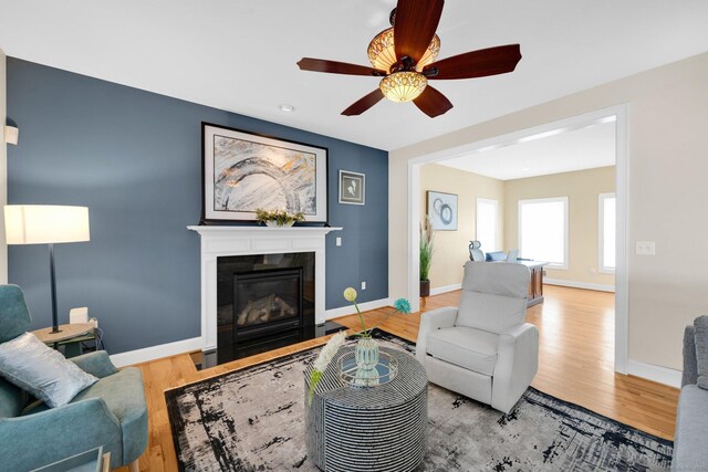 15 Lafountain Rd, Suffield, CT 06078 - living area featuring a fireplace with flush hearth, wood finished floors, ceiling fan, and baseboards