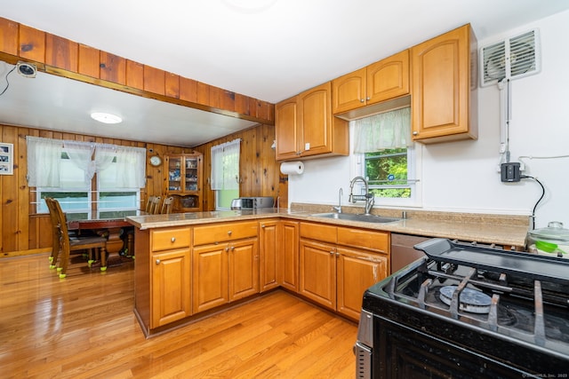 45 Valley Rd, Hamden, CT 06514 - kitchen featuring black gas range, a peninsula, a sink, light wood finished floors, and wooden walls