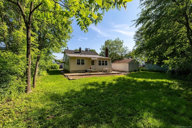 45 Valley Rd, Hamden, CT 06514 - back of house with a patio, a lawn, an outbuilding, and a chimney
