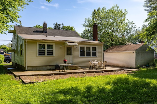 45 Valley Rd, Hamden, CT 06514 - rear view of house featuring a chimney, a patio area, a yard, and an outdoor structure