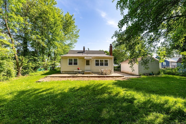 45 Valley Rd, Hamden, CT 06514 - rear view of house with a lawn, a patio, a chimney, and an outbuilding
