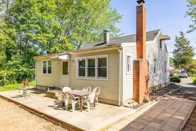45 Valley Rd, Hamden, CT 06514 - back of property featuring a chimney, a patio area, outdoor dining area, and a shingled roof