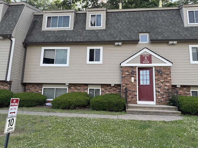 68 Evergreene Unit 68, Wallingford, CT 06492 - view of front facade with a shingled roof, brick siding, and a front lawn