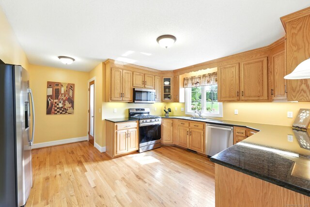 7 Brook Wood Ct, East Windsor, CT 06016 - kitchen with appliances with stainless steel finishes, light wood-style floors, baseboards, glass insert cabinets, and dark stone countertops