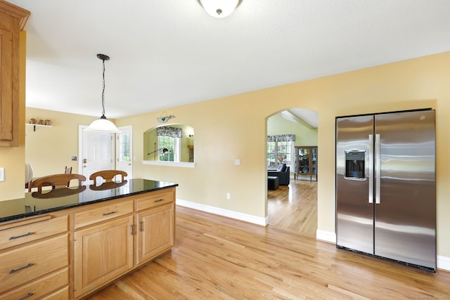 7 Brook Wood Ct, East Windsor, CT 06016 - kitchen with stainless steel fridge with ice dispenser, arched walkways, light wood-style floors, dark countertops, and hanging light fixtures