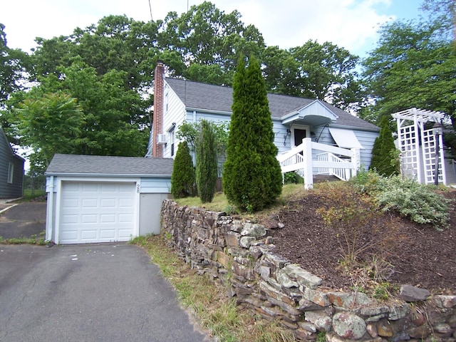 28 Terrace Ave, East Hartford, CT 06108 - view of front of property with a garage, asphalt driveway, a chimney, a shingled roof, and an outbuilding