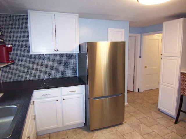 28 Terrace Ave, East Hartford, CT 06108 - kitchen featuring freestanding refrigerator, white cabinetry, decorative backsplash, and dark countertops