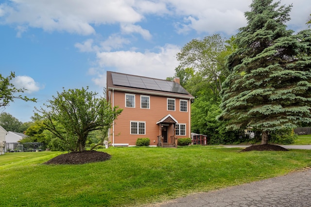 9 Purdum Rd, New Fairfield, CT 06812 - view of front facade featuring roof mounted solar panels, a front lawn, and a chimney