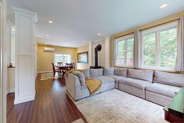 9 Purdum Rd, New Fairfield, CT 06812 - living room featuring a wood stove, a wall unit AC, dark wood-style flooring, recessed lighting, and baseboards