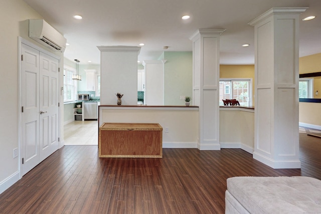 9 Purdum Rd, New Fairfield, CT 06812 - kitchen featuring a wall mounted AC, appliances with stainless steel finishes, dark wood-style flooring, decorative columns, and white cabinetry
