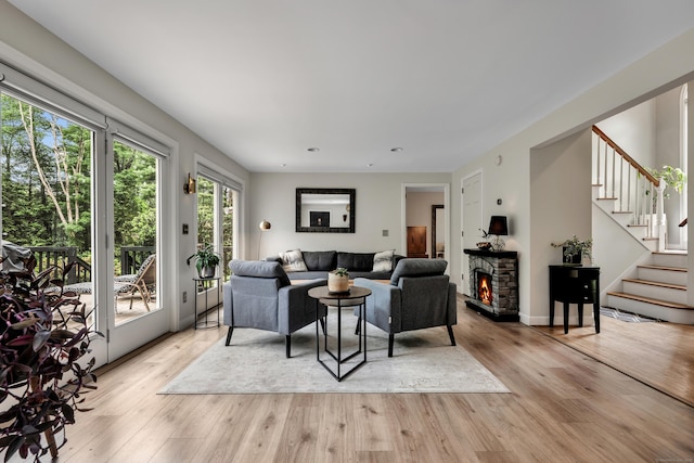 89 Goose Green Rd, Barkhamsted, CT 06063 - living room featuring a stone fireplace, stairway, and light wood-type flooring