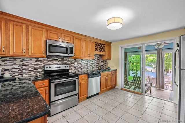525 Park Ave, Windsor, CT 06095 - kitchen featuring stainless steel appliances, decorative backsplash, light tile patterned flooring, and brown cabinets