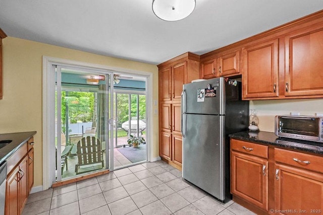 525 Park Ave, Windsor, CT 06095 - kitchen with stainless steel appliances, brown cabinetry, light tile patterned floors, and baseboards
