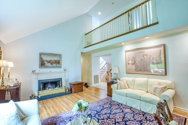 510 W Lyon Farm Dr Unit 510, Greenwich, CT 06831 - living area with high vaulted ceiling, wood finished floors, stairway, a fireplace with raised hearth, and baseboards