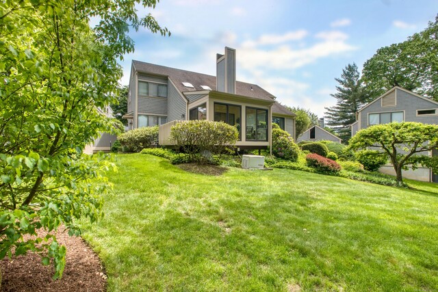 510 W Lyon Farm Dr Unit 510, Greenwich, CT 06831 - back of house with a chimney, a lawn, and a sunroom