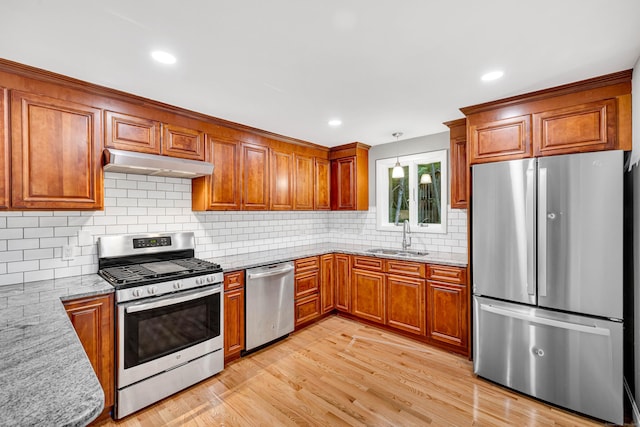 53 Windham Rd, Hampton, CT 06247 - kitchen with appliances with stainless steel finishes, under cabinet range hood, a sink, brown cabinetry, and light stone countertops