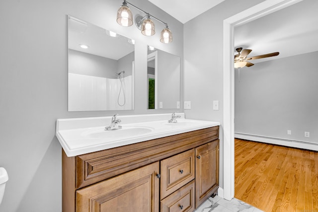 53 Windham Rd, Hampton, CT 06247 - full bathroom featuring a baseboard radiator, double vanity, a ceiling fan, toilet, and a shower