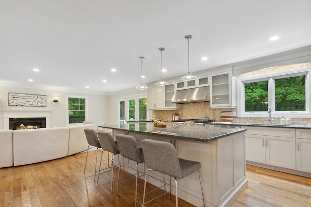 24 Pine Mountain Rd, Redding, CT 06896 - kitchen with under cabinet range hood, a sink, backsplash, dark stone countertops, and a breakfast bar