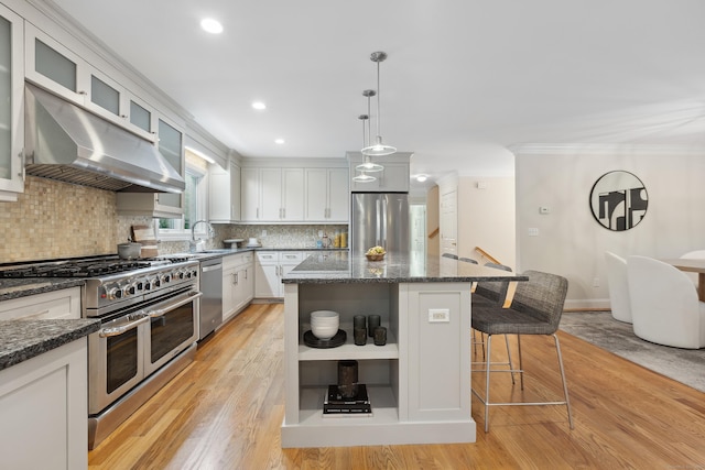 24 Pine Mountain Rd, Redding, CT 06896 - kitchen with appliances with stainless steel finishes, under cabinet range hood, a breakfast bar area, light wood finished floors, and crown molding