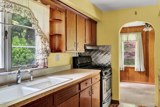 5 Reservoir Rd, Norwich, CT 06360 - kitchen with stainless steel gas stove, a sink, light countertops, under cabinet range hood, and arched walkways