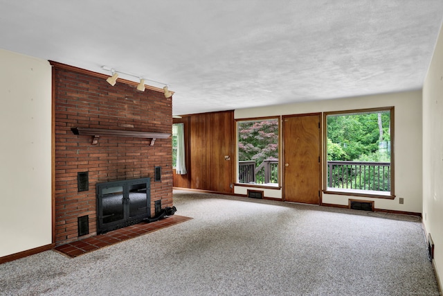 5 Reservoir Rd, Norwich, CT 06360 - unfurnished living room with a brick fireplace, carpet flooring, rail lighting, and baseboards