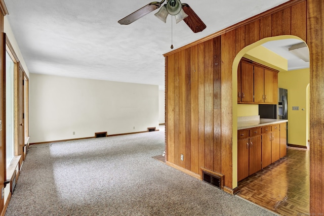 5 Reservoir Rd, Norwich, CT 06360 - unfurnished room with a ceiling fan, wooden walls, baseboards, arched walkways, and carpet