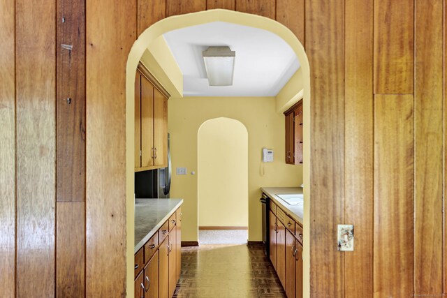 5 Reservoir Rd, Norwich, CT 06360 - kitchen featuring arched walkways, brown cabinets, light countertops, baseboards, and a sink