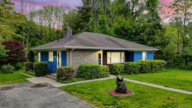 5 Reservoir Rd, Norwich, CT 06360 - view of front of home with stone siding, a chimney, a lawn, and a shingled roof