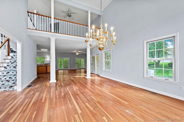 657 Tamarack Rd, Cheshire, CT 06410 - unfurnished living room with a ceiling fan, a high ceiling, wood finished floors, and stairway