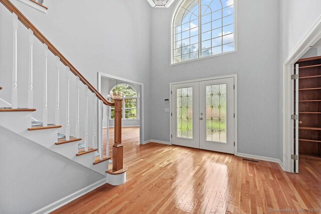 657 Tamarack Rd, Cheshire, CT 06410 - entryway featuring a towering ceiling, french doors, stairs, baseboards, and wood-type flooring
