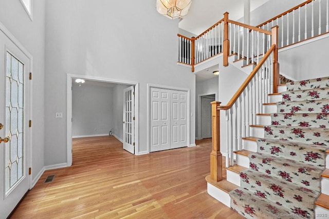 657 Tamarack Rd, Cheshire, CT 06410 - foyer entrance with a high ceiling, light wood-type flooring, stairs, and baseboards