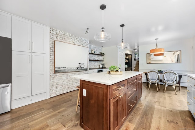 30 Norfield Woods Rd, Weston, CT 06883 - kitchen with light wood finished floors, brick wall, stainless steel fridge, a center island, and hanging light fixtures