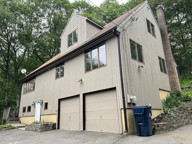209 S Main St, Plymouth, CT 06786 - view of property exterior with an attached garage, a chimney, and asphalt driveway