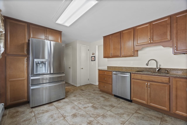 20 Laurel Wood Rd, North Stonington, CT 06359 - kitchen with appliances with stainless steel finishes, dark stone countertops, brown cabinetry, and a baseboard heating unit