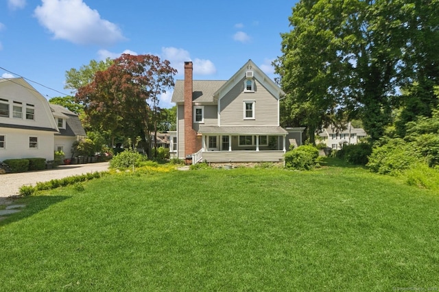 8 Washington Ave, Westport, CT 06880 - back of property featuring a chimney, a lawn, and a sunroom