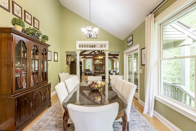 61 Baldwin Brook Rd, Canterbury, CT 06331 - dining area featuring decorative columns, high vaulted ceiling, light wood-style flooring, baseboards, and a chandelier